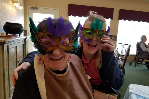 Two women enjoying a joyful moment while wearing colorful masks.