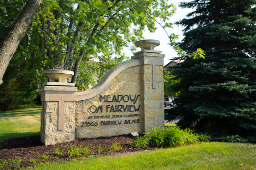 Entrance sign for Meadows on Fairview, surrounded by lush greenery.