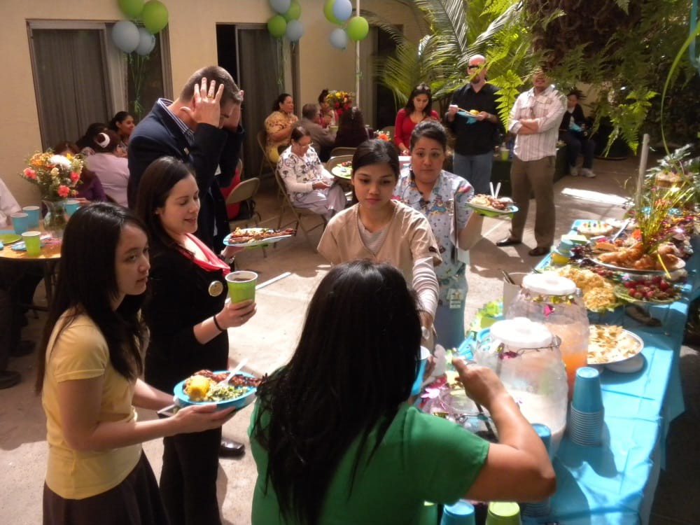 A group of people enjoying food and drinks at an outdoor gathering.