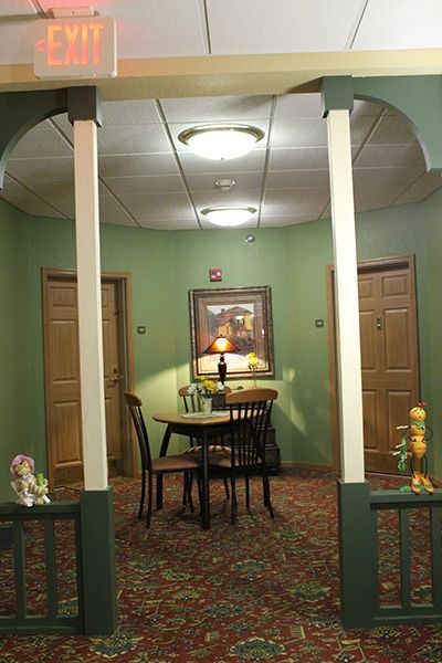 A cozy hallway with a small table and chairs, surrounded by doors and soft lighting.