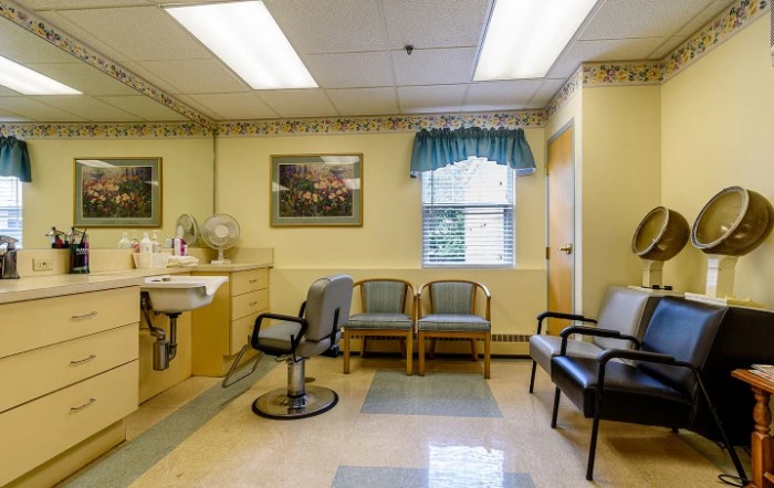 A well-lit waiting room with several chairs and a window.
