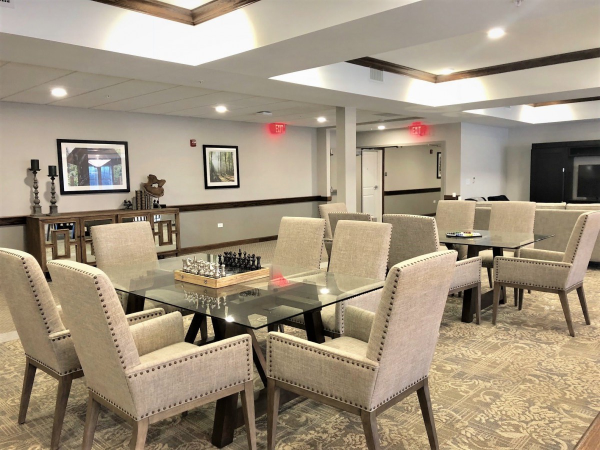 A modern dining area with a glass table and upholstered chairs in a tastefully decorated room.