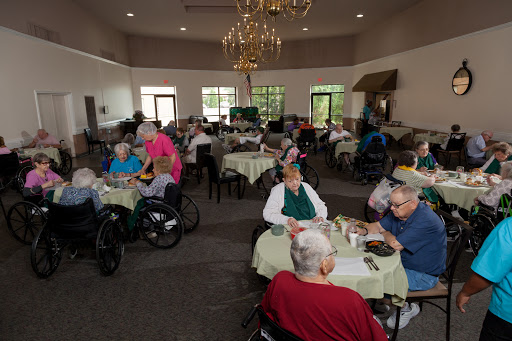 Residents enjoying a meal and socializing in a care home dining area.
