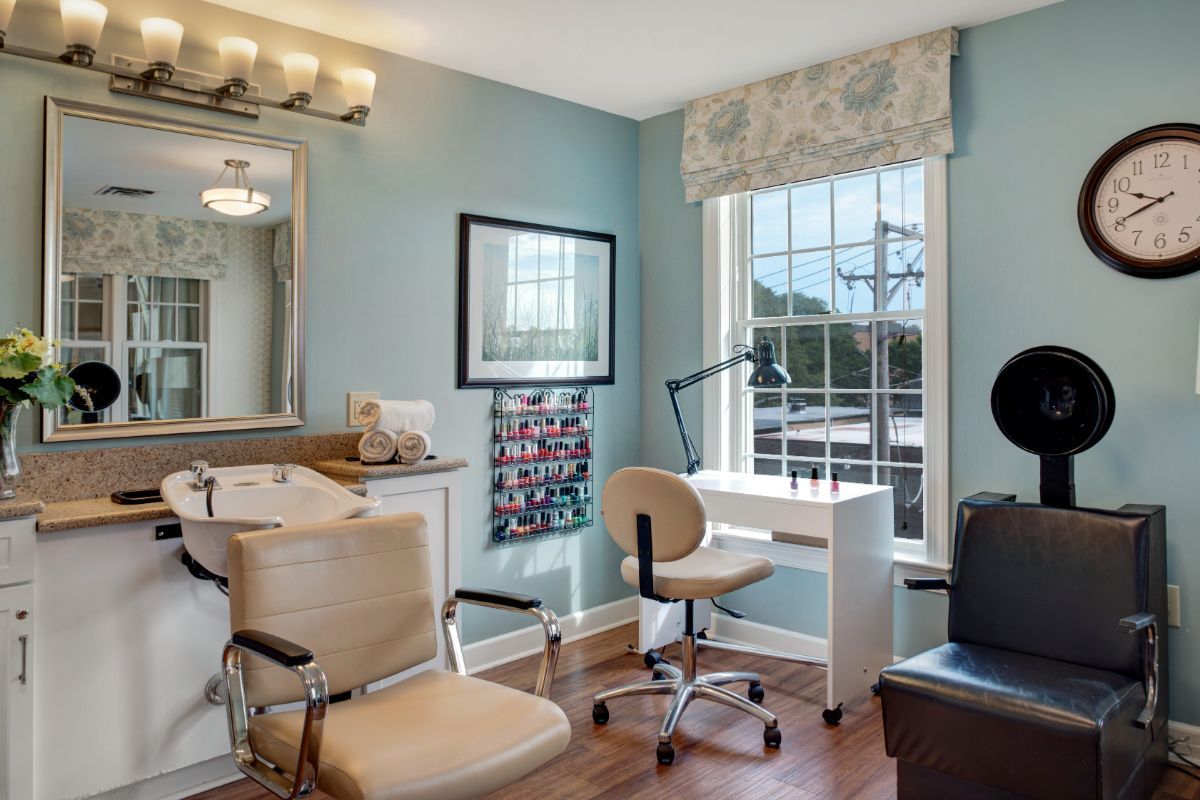 A well-lit salon interior with a styling chair and vanity setup.