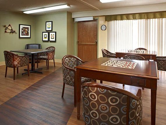 A cozy room with wooden tables and patterned chairs, featuring a warm interior decor.