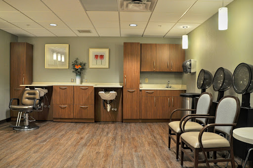 A cozy and well-decorated waiting room in a medical facility, featuring comfortable seating and modern cabinetry.