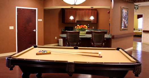 A cozy game room featuring a billiards table and a stylish bar area.