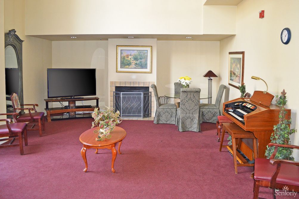 A cozy living room with a television, fireplace, and various furniture pieces.