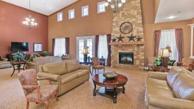 A spacious living room with a stone fireplace and elegant decor.