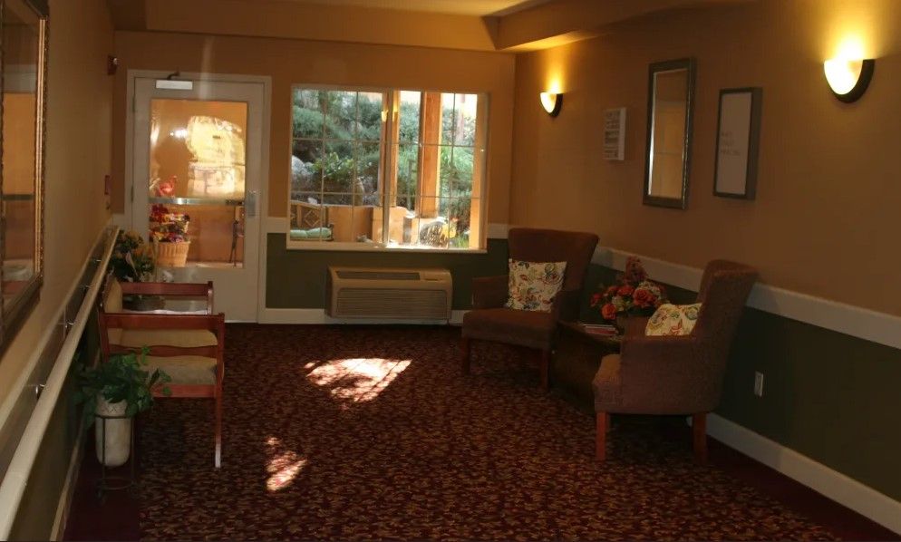 A cozy living room with comfortable seating, warm lighting, and large windows overlooking a scenic view.