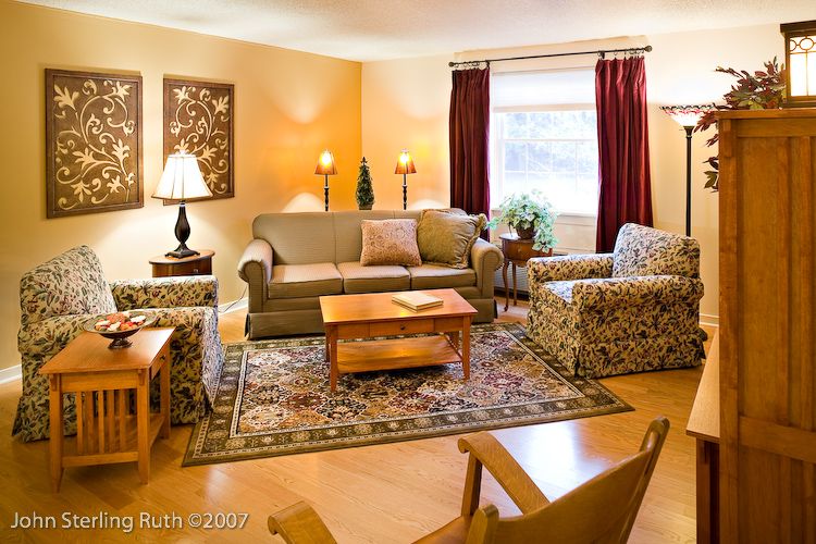 A cozy living room with comfortable seating, a coffee table, and warm lighting.