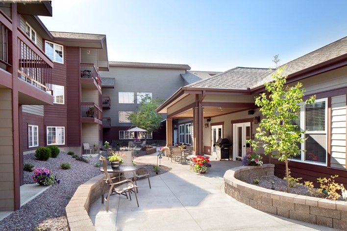 A modern courtyard with outdoor seating and landscaping on a sunny day.