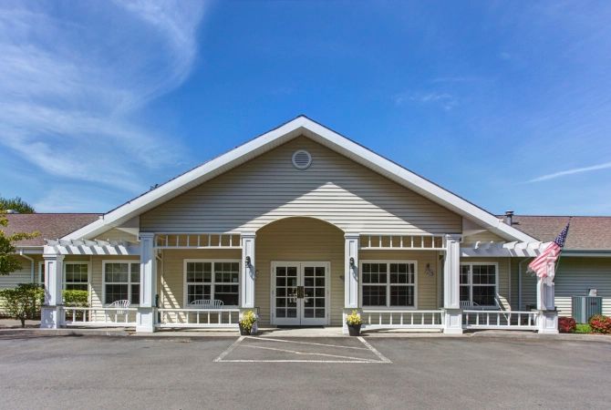 A symmetrical building with a prominent entryway against a clear blue sky.
