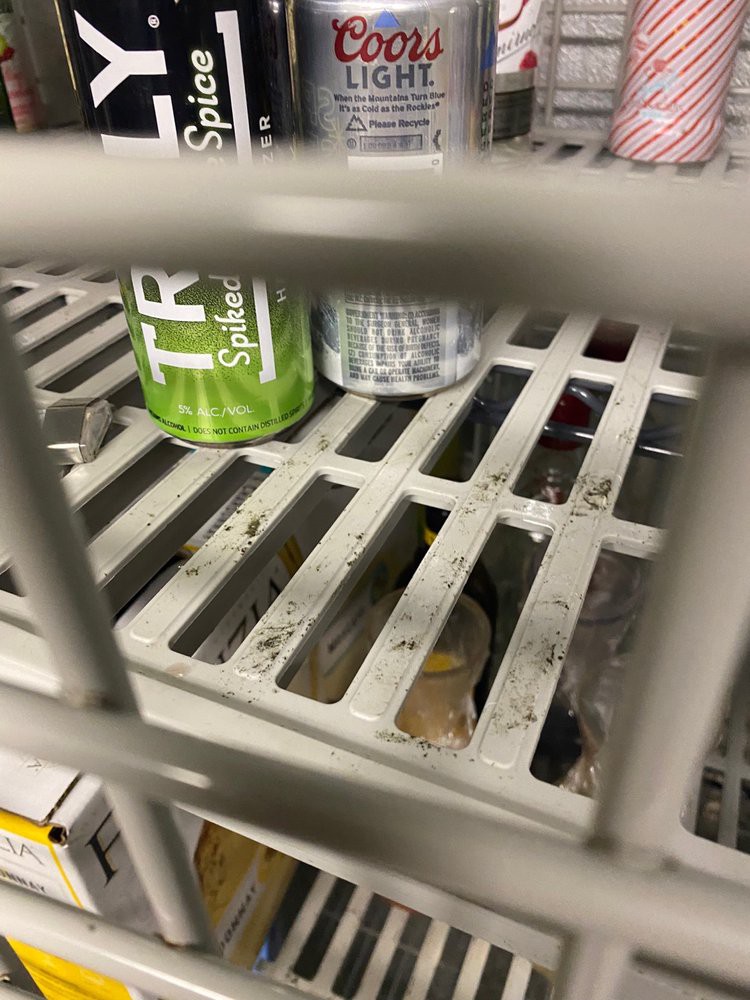 Cans stored on a metal grate shelf in an industrial setting.