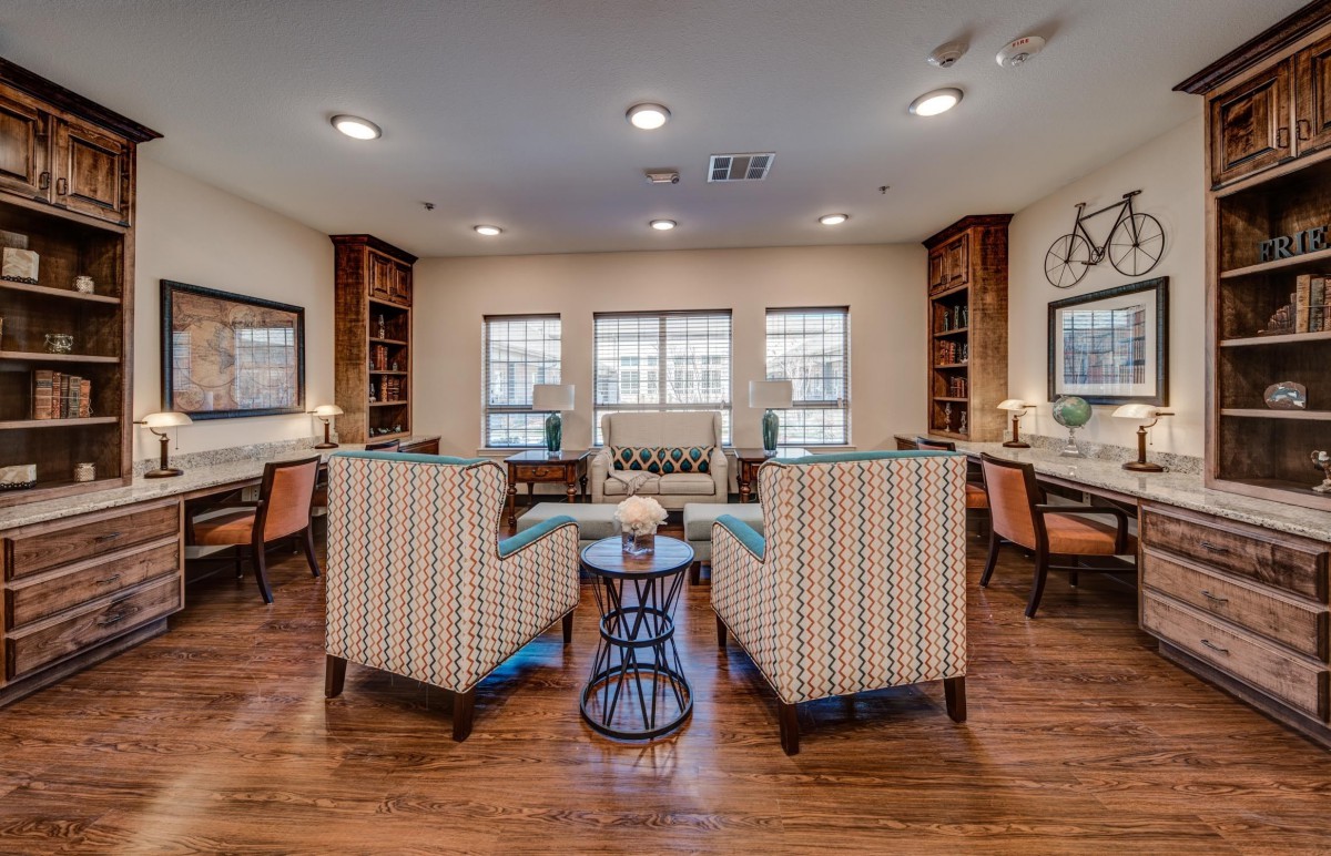 A cozy living room with comfortable seating, bookshelves, and natural lighting.