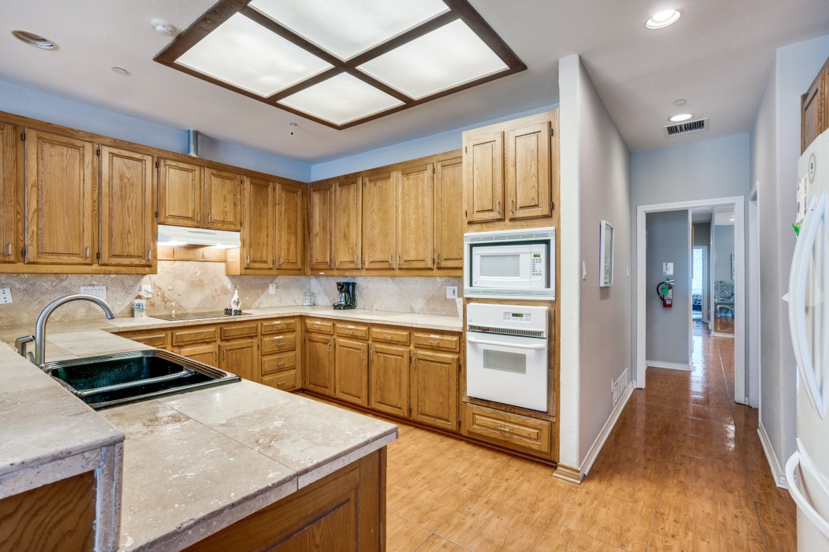 A modern kitchen with wooden cabinets and built-in appliances.