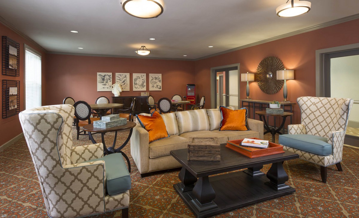 A cozy and elegantly designed living room featuring a comfortable sofa with orange cushions, a coffee table, and tasteful decorations.