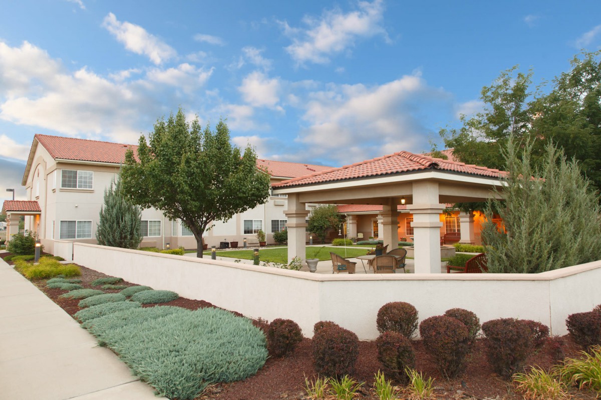 A beautiful home with a well-maintained garden and clear blue sky.