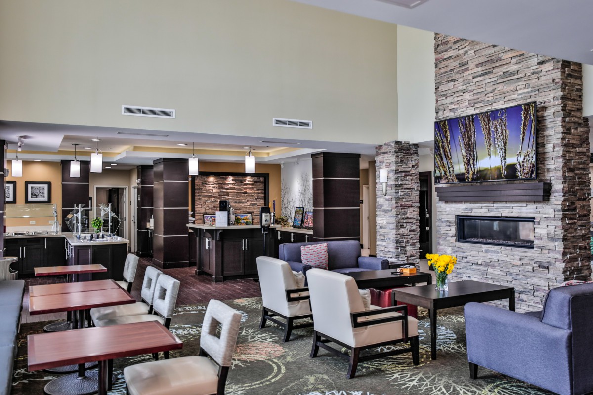 A modern hotel lobby with comfortable seating and a fireplace.
