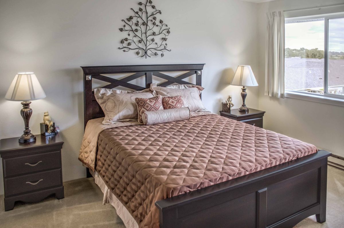 A cozy bedroom with a neatly made bed and stylish decor.