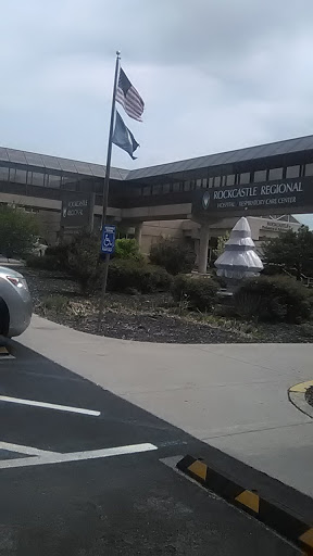 View of a modern building with a flag and landscaped surroundings.