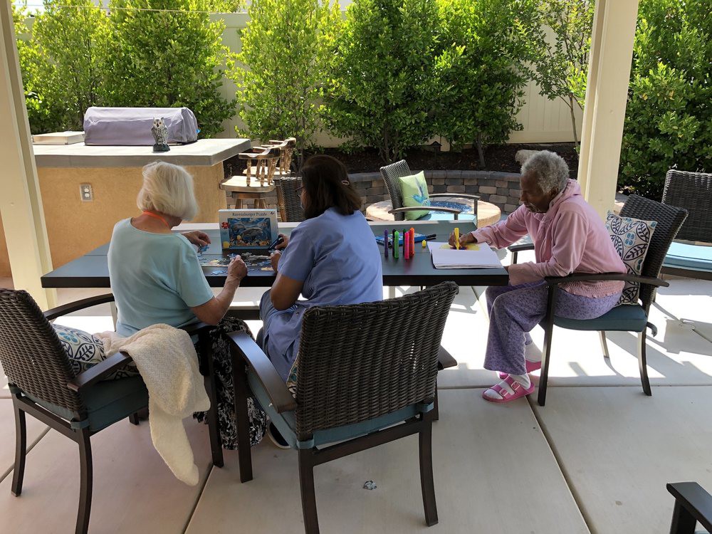 A group of people engaged in crafting activities outdoors on a sunny day.