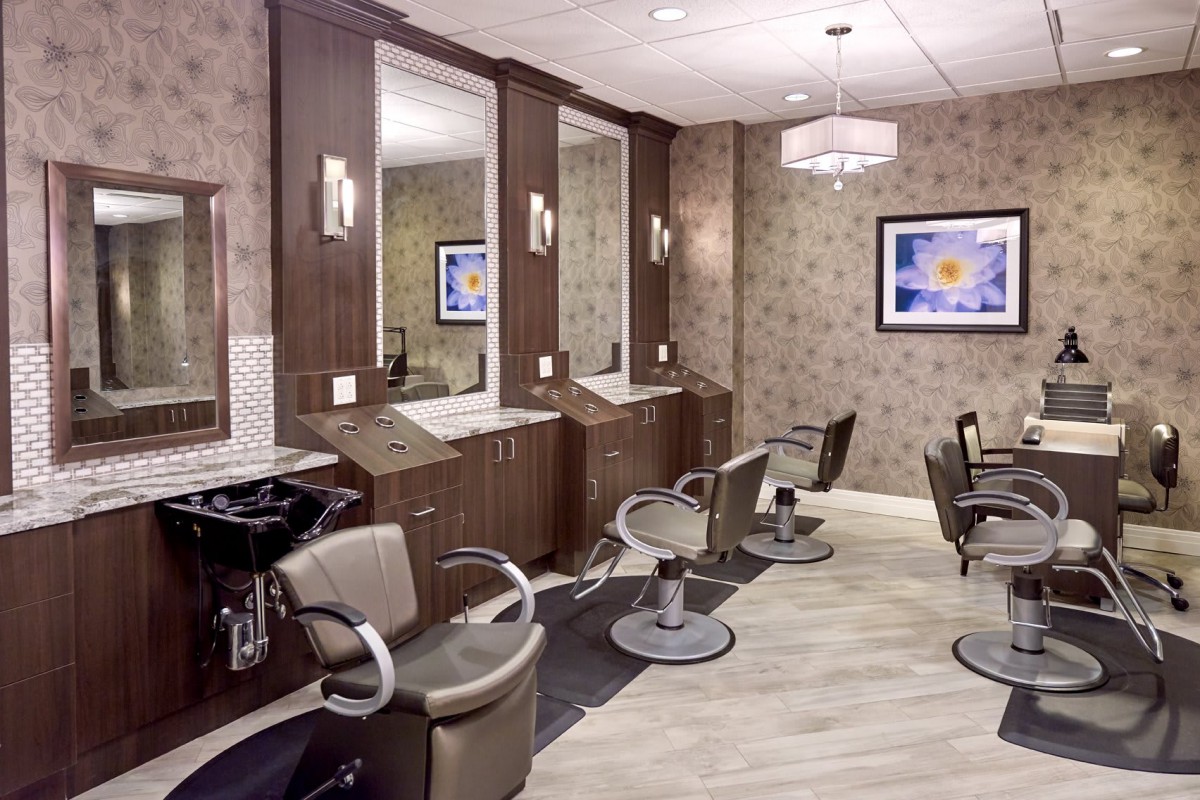 A modern hair salon with styling stations and comfortable chairs.