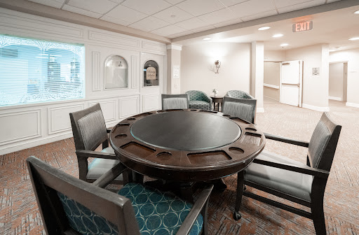 A cozy dining area featuring a round wooden table and upholstered chairs.