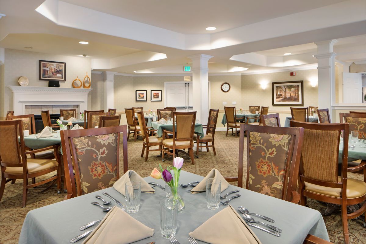 An elegant dining room with neatly arranged tables and chairs, featuring decorative table settings.