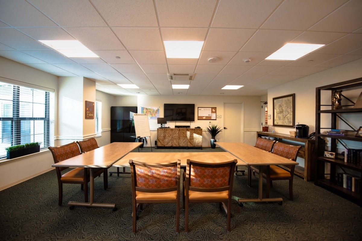 A conference room with a large table and several chairs, designed for meetings.