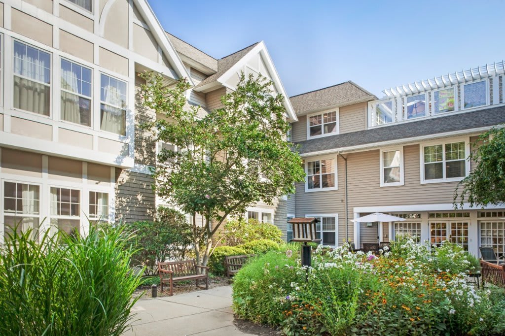 A peaceful courtyard surrounded by residential buildings with lush greenery.