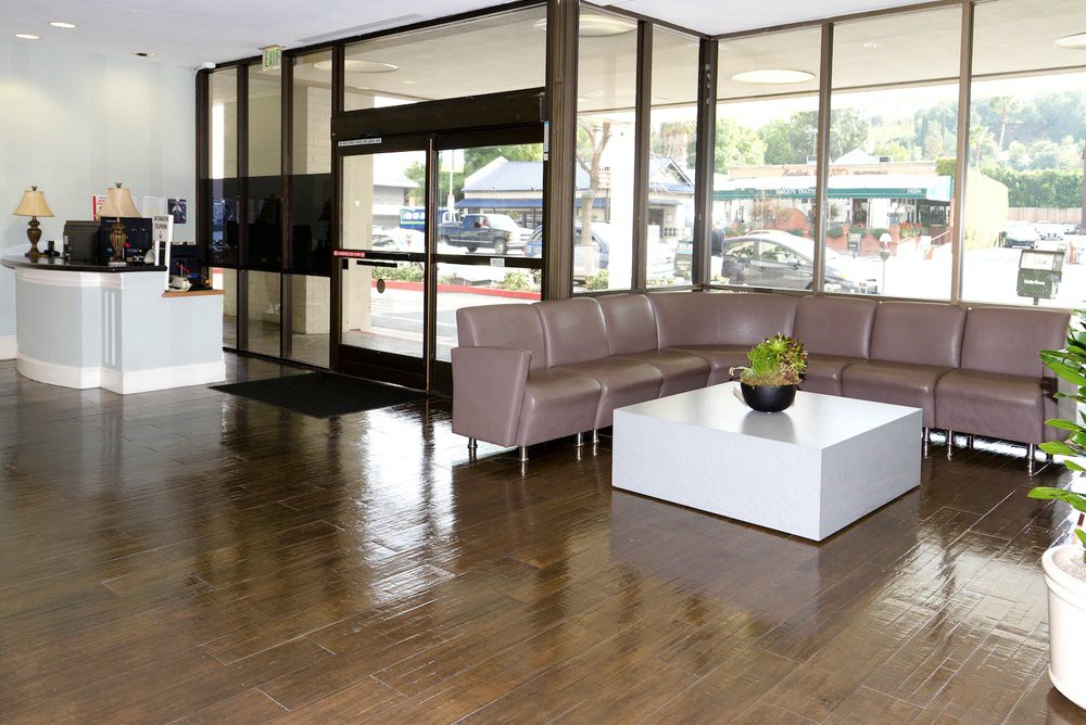 A modern lobby with a sleek sofa and table arrangement near glass doors.