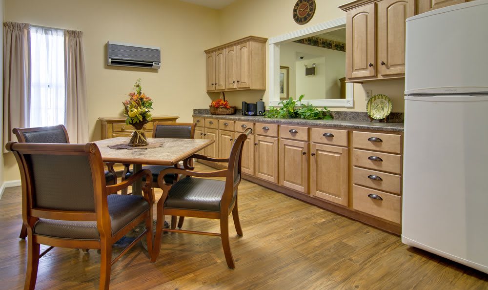 A cozy kitchen and dining area with wooden cabinets and a dining table set.