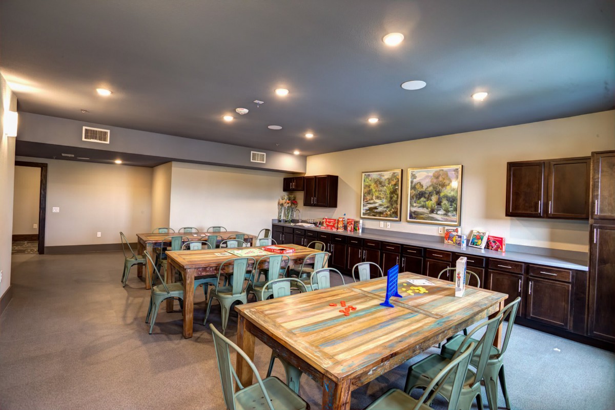 A modern dining area with colorful wooden tables and artwork on the walls.