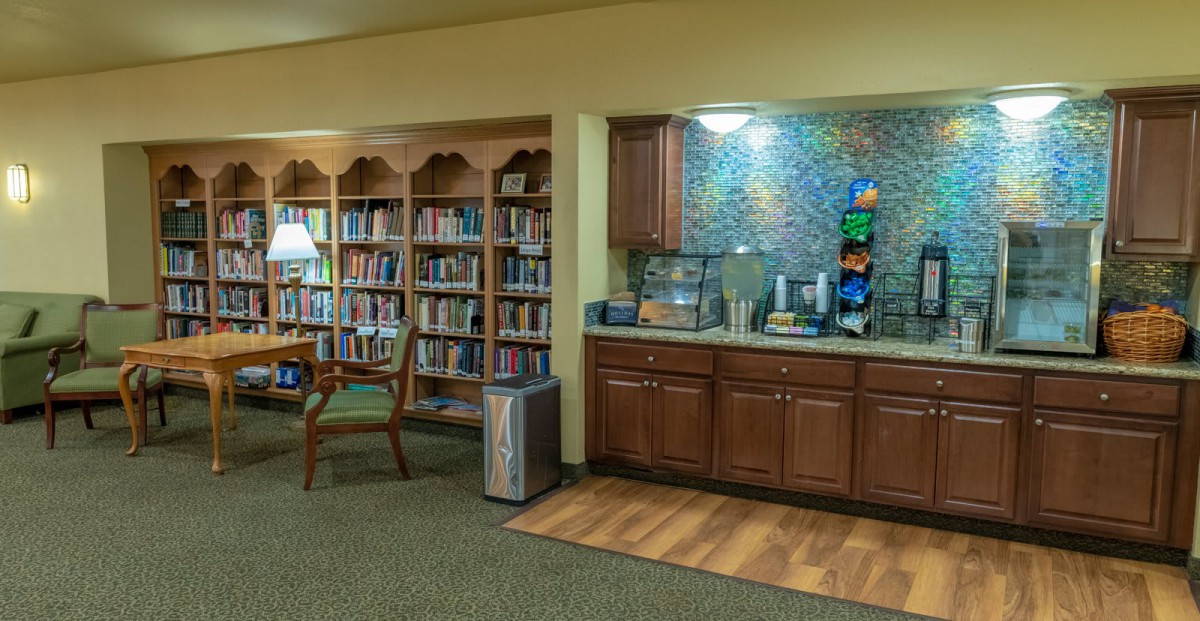 A cozy library corner featuring a bookshelf and a coffee station.