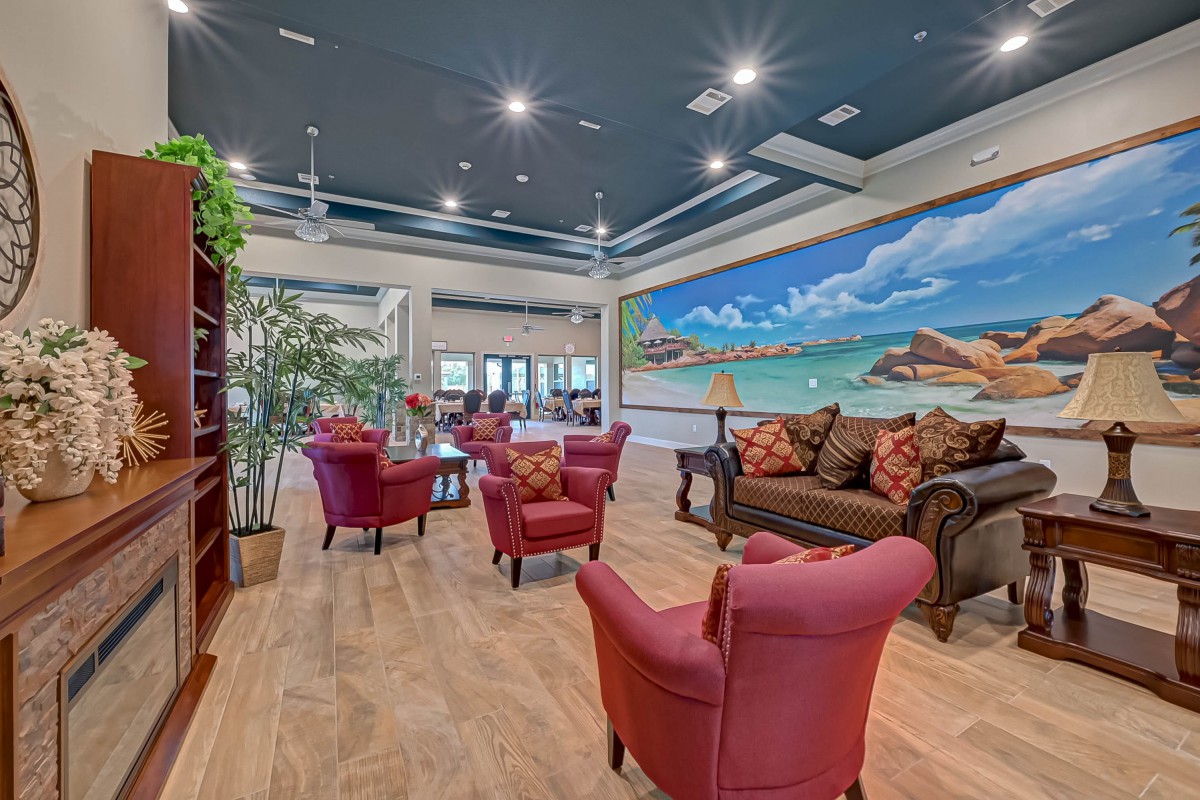 A cozy and modern living room featuring vibrant seating and a large mural.