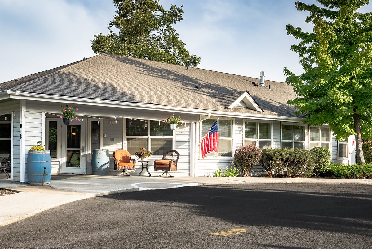 A residential house with outdoor seating and an American flag displayed near the entrance.