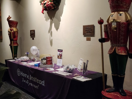 A decorated exhibition table showcasing promotional materials next to a nutcracker figure.