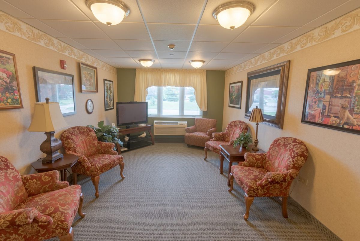 A traditionally decorated living room with elegant seating and a television.