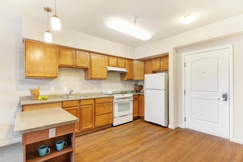 A modern kitchen with wooden cabinets and standard appliances.