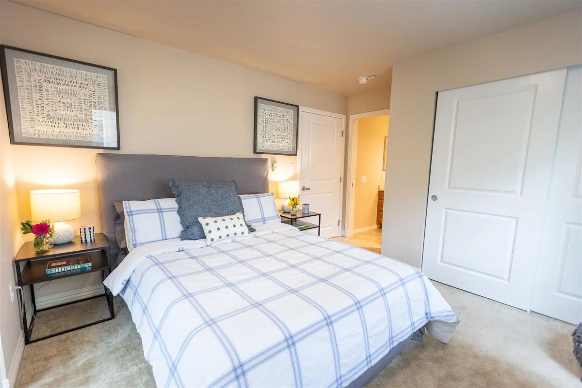 A cozy bedroom with a neatly made bed and inviting decor.