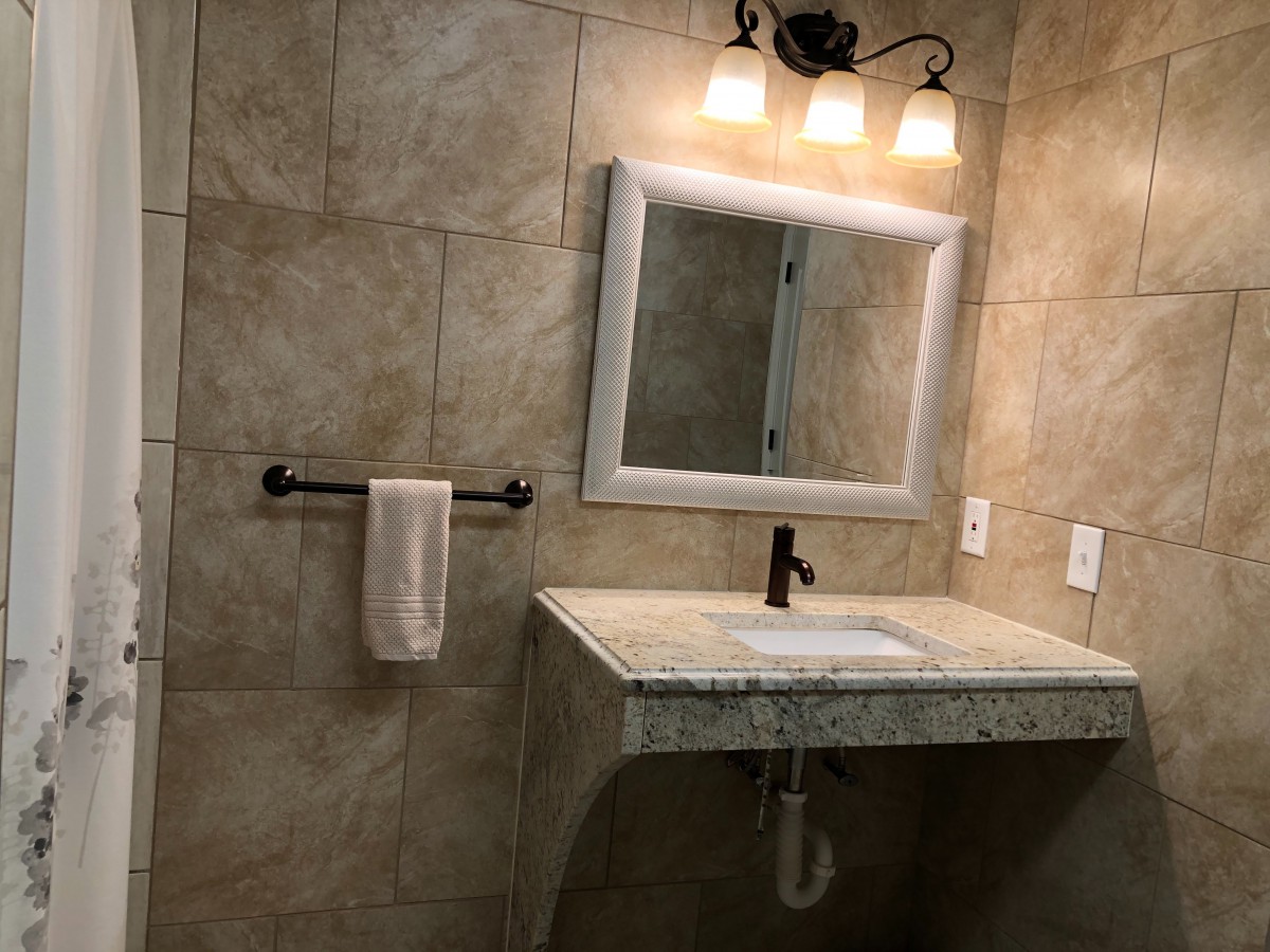 A modern bathroom with a stylish sink and well-lit mirror.