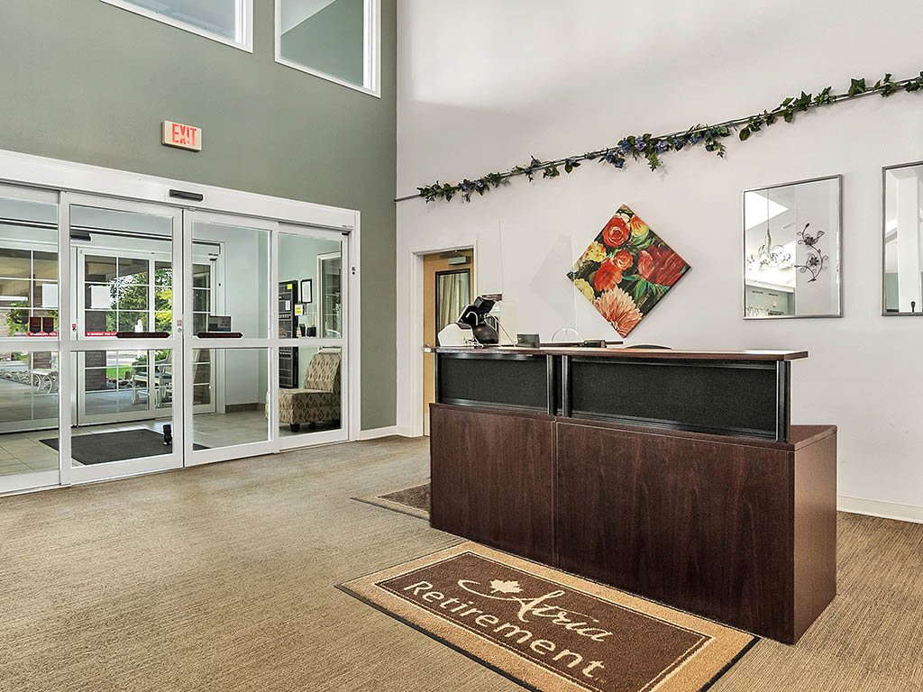 A welcoming reception area with a desk, decor, and entrance doors.