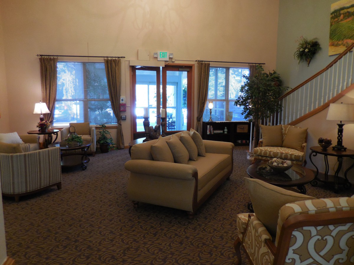 A cozy living room with sofas, large windows, and elegant curtains.