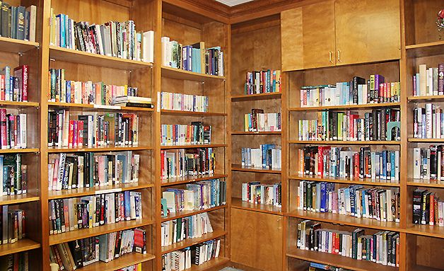 A cozy corner of a library with wooden bookshelves filled with books.