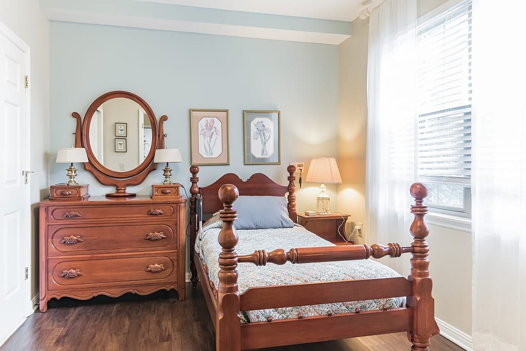 A traditional bedroom with wooden furniture and soft lighting.
