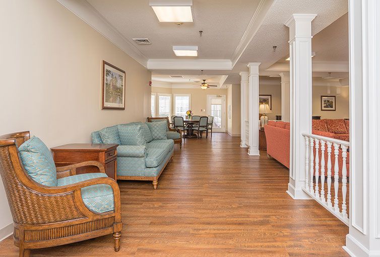 Spacious living area with hardwood flooring, comfortable seating, and classic interior design elements.