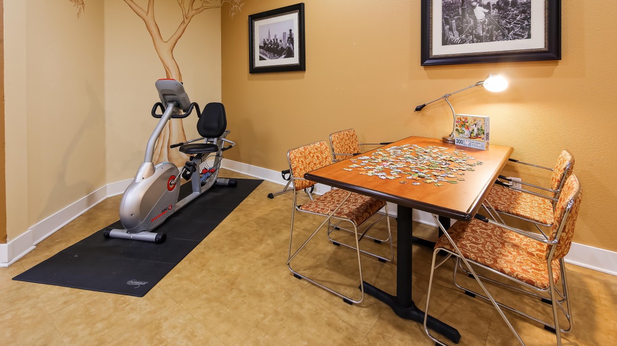 A cozy indoor space featuring an exercise bike and a table set up for a puzzle.