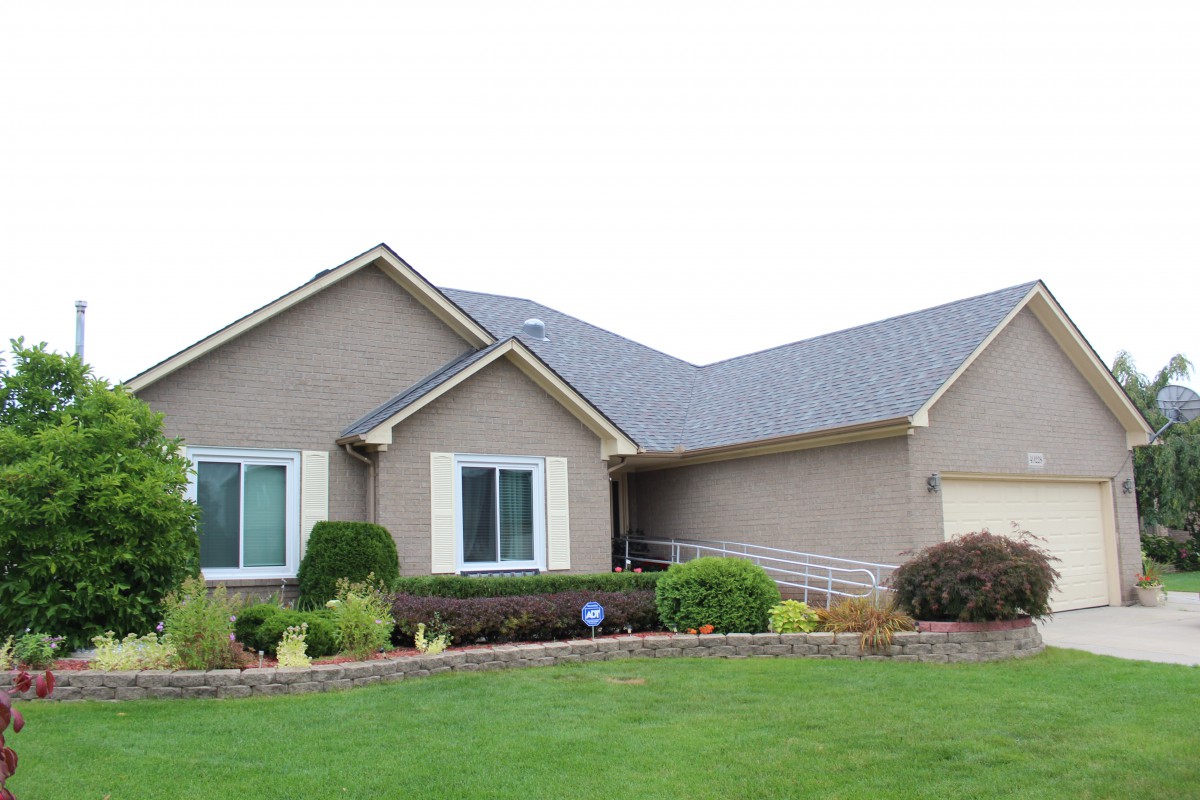 A suburban house with a well-maintained lawn and landscaping.