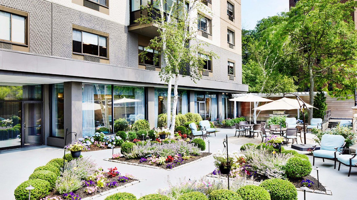 A beautifully landscaped garden area with outdoor seating in front of a modern building.